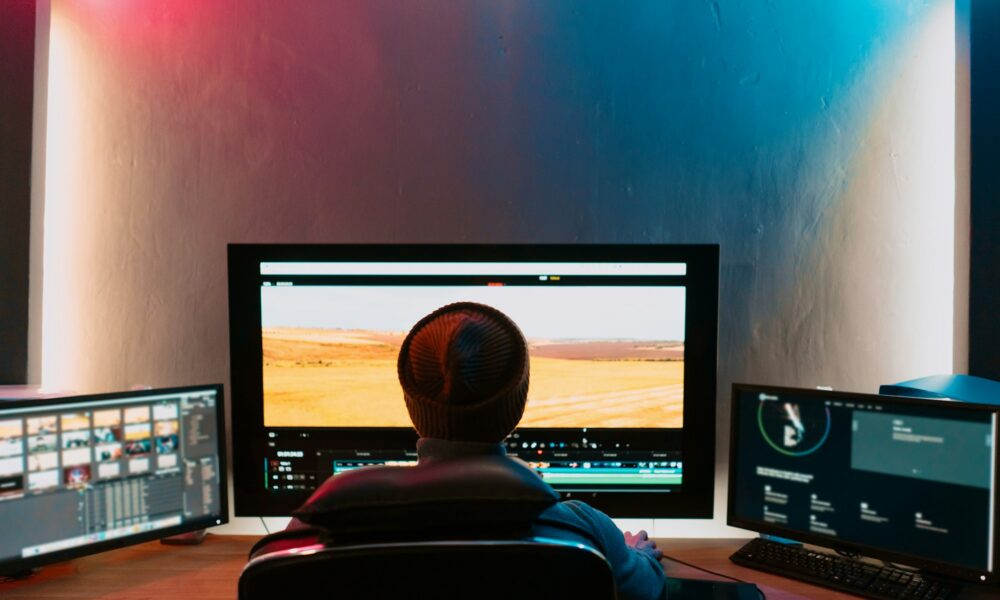 Male Video Editor Working on His Personal Computer with Big Display