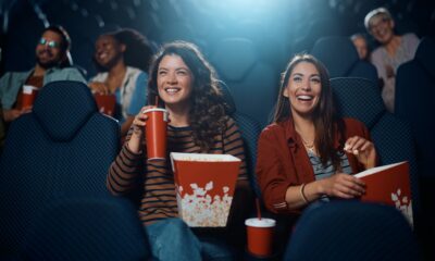 Young happy women watching movie in cinema.