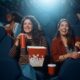 Young happy women watching movie in cinema.